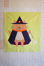 Load image into Gallery viewer, Quilt block with a cat in a witch costume on a textured wall. The Weekend Quilter Halloween Catwalk Series Hattie Cat Mini Quilt Pattern