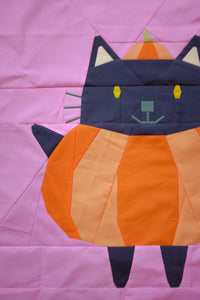 Patchwork cat design on a pink background. The Weekend quilter Halloween Catwalk series Jackie Cat mini Quilt pattern