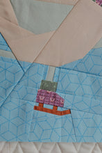 Load image into Gallery viewer, A close-up of a quilted textile featuring a light blue patterned section, a beige collar-like panel, and a small central patchwork motif in pink, orange, and gray. The Weekend Quilter Frosty Flappers quilt block (Beaks on Ice Series)