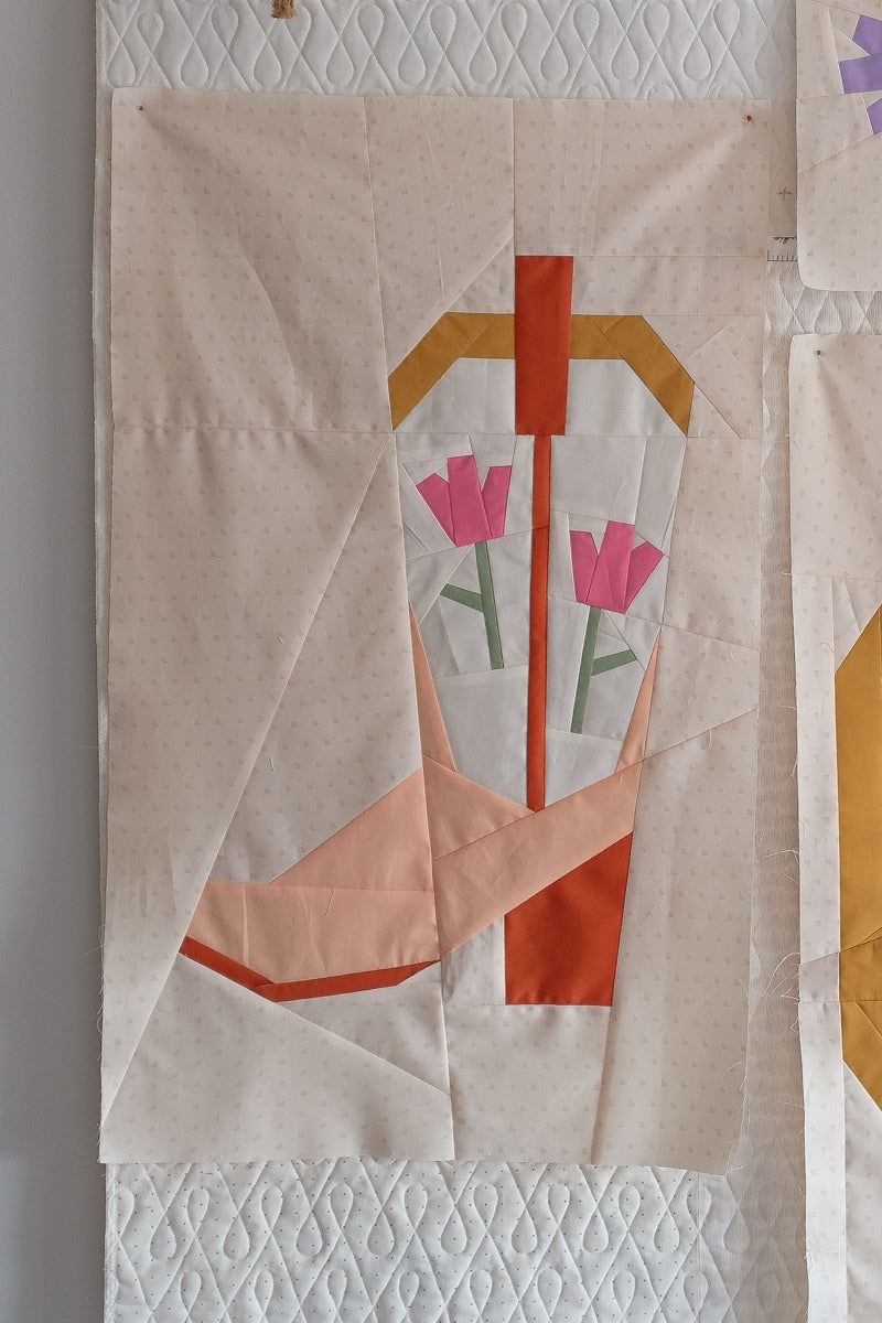 Blushing Boot foundation paper pieced quilt block by The Weekend Quilter, featuring a modern pink and orange cowboy boot with tulip flowers on a soft cream background. Western-themed mini quilt pattern for modern quilters, perfect for wall hangings or incorporating into larger quilt projects. Beginner-friendly FPP design with step-by-step instructions.