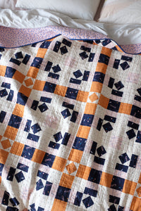 The Weekend Quilter Plaidful Modern Quilt Pattern for confident beginners in throw styled on bed
