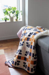 The Weekend Quilter Plaidful Modern Quilt Pattern for confident beginners in throw styled on couch